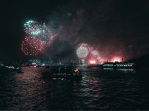 Barcos amarrados en Marina Vela Barcelona durante la noche de San Juan con fuegos artificiales al fondo